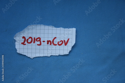 Sheet of paper with 2019 ncov inscription. Word coronavirus. Blue background witd china virus concept. Ncov in Poland, USA, Europe, Germany, France and all world. photo