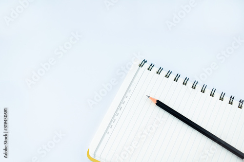 Wallpaper Mural Single black wood pencil on a white notebook in an isolated white background Torontodigital.ca