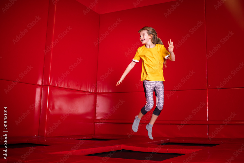 Child having fun while jumping on trampoline in fitness center Child having fun while jumping on trampoline in fitness center