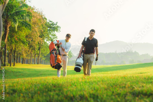 Golf player walking and carrying bag on course during summer game golfing