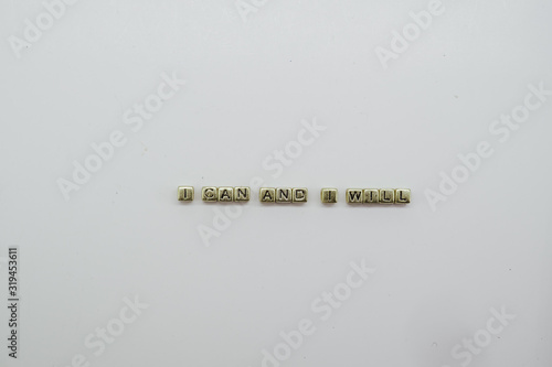 I Can and I will text spelled out in gold dice blocks on white background.