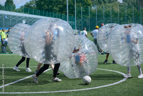 Bubble football. People kicking ball on a football field photo