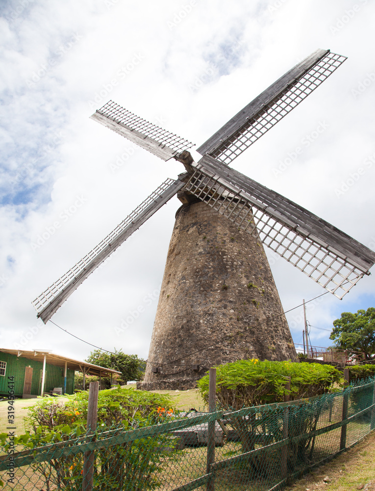 View of an old mill against a blue sky of clouds on a clear Sunny day, Barbados island. Architecture, world tourism, landscape, architecture. View of an old mill against a blue sky of clouds on a clear Sunny day, Barbados island. Architecture, world tourism, landscape, architecture.