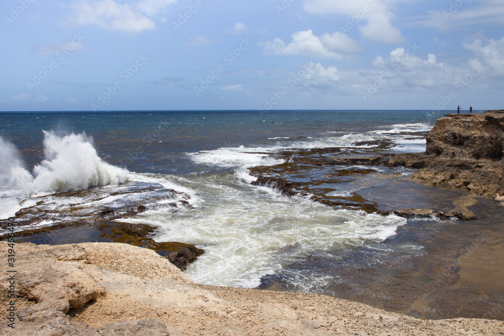 View of the beautiful rocky coast of the Atlantic ocean with raging waves on a Sunny day against a blue sky of clouds, the island of Barbados. World tourism, recreation, landscape. View of the beautiful rocky coast of the Atlantic ocean with raging waves on a Sunny day against a blue sky of clouds, the island of Barbados. World tourism, recreation, landscape.