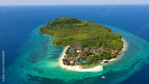 Himokilan Island, Leyte Island, Philippines. Tropical island with a village and a white beach. Turquoise water and coral reefs around the island. Summer holiday vacation concept.