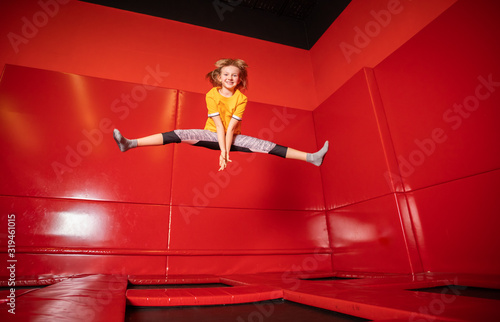 Little girl jumping on trampoline in fly park photo