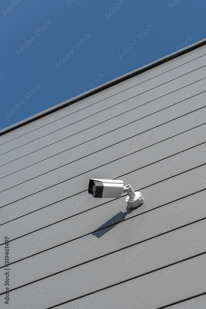 CCTV Security camera on building wall geometric linear grey sunny silver CCTV Security camera on building wall geometric linear grey sunny silver