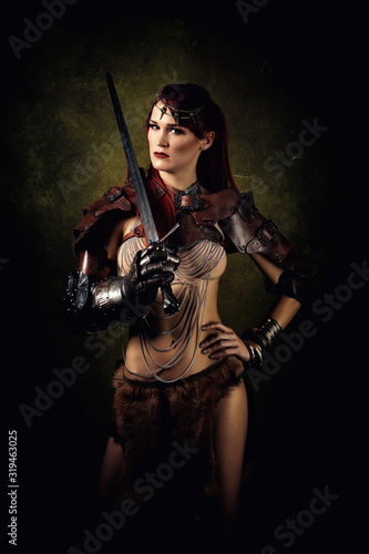 Portrait of a sexy warrior with a sword on her shoulder