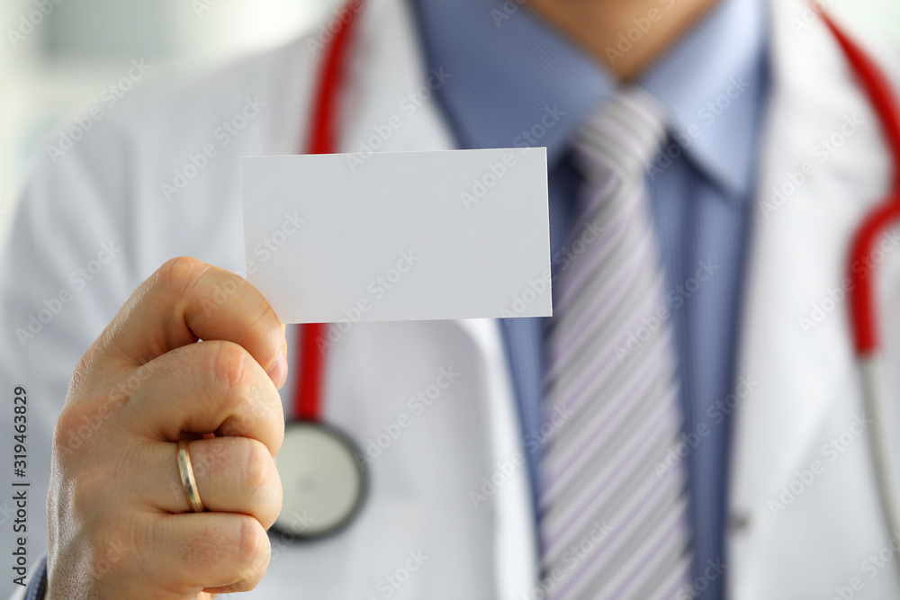 Male medicine doctor hand holding blank calling card Male medicine doctor hand holding blank calling card