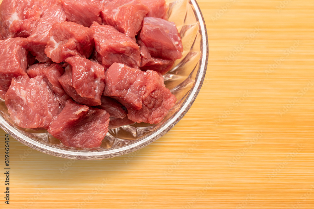 fresh raw diced beef meat in a glass plate on cutting board fresh raw diced beef meat in a glass plate on cutting board