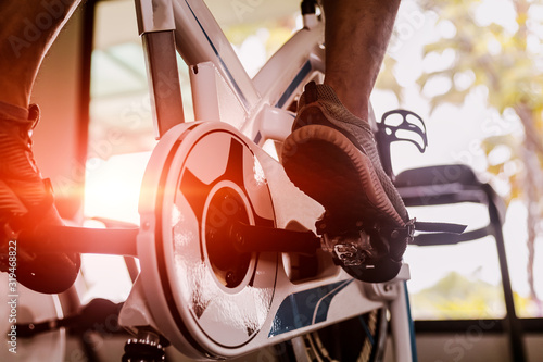 Fit man working out on exercise bike at the gym. Healthy and funny lifestyle concept.