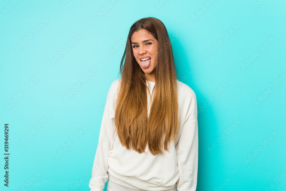 Young slim woman funny and friendly sticking out tongue. Young slim woman funny and friendly sticking out tongue.