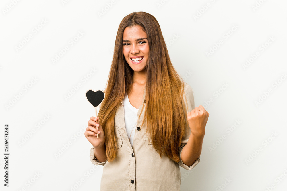 Young caucasian woman holding a heart shape cheering carefree and excited. Victory concept. Young caucasian woman holding a heart shape cheering carefree and excited. Victory concept.
