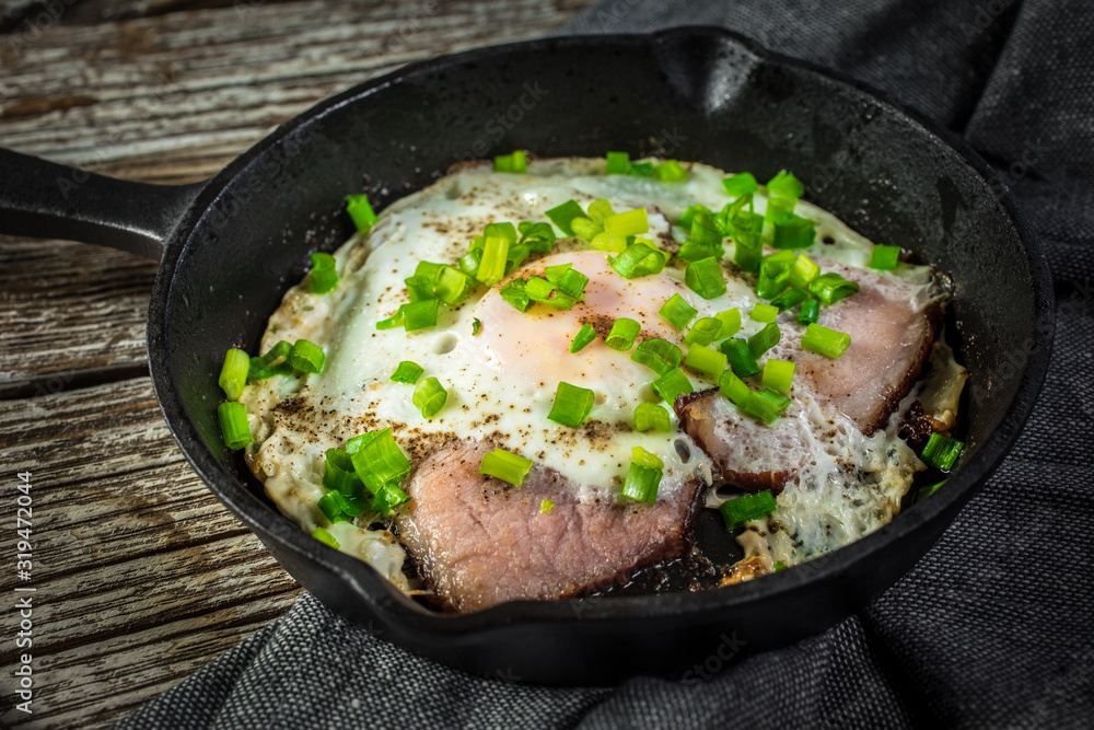 Fried eggs with ham on an old wooden background. Fried eggs with ham on an old wooden background.