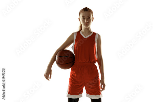 Young caucasian female basketball player posing confident isolated on white background. Redhair sportive girl. Concept of sport, movement, energy and dynamic, healthy lifestyle. Training, practicing. © master1305