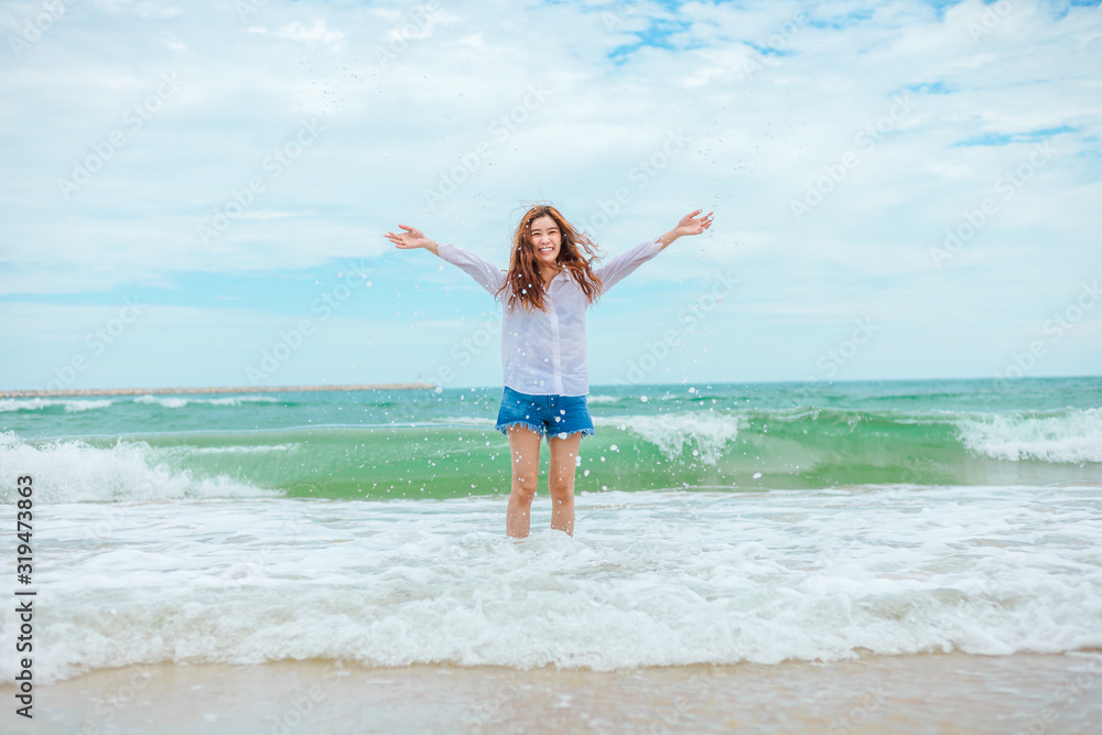Young woman playful on tropical beach have fun playing water splash in freedom with open arms. Young woman playful on tropical beach have fun playing water splash in freedom with open arms.