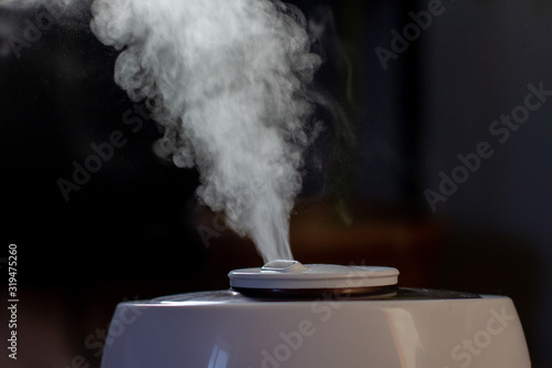 white steam from a humidifier on a black background