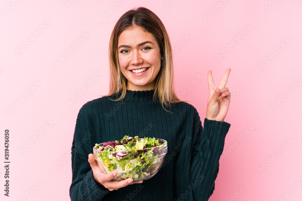 Young caucasian woman holding a salad isolated showing number two with fingers. Young caucasian woman holding a salad isolated showing number two with fingers.