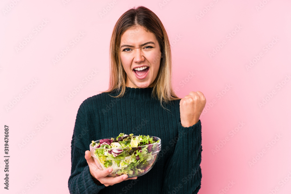 Young caucasian woman holding a salad isolated cheering carefree and excited. Victory concept. Young caucasian woman holding a salad isolated cheering carefree and excited. Victory concept.