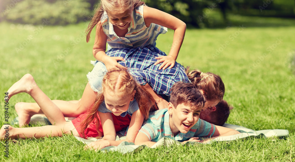 Fototapeta premium friendship, childhood, leisure and people concept - group of happy kids or friends playing and having fun in summer park