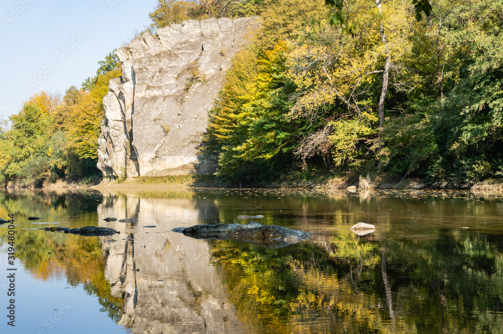 Autumn landscape with Cockerel Rock reflected in mountain river Psekups.  Sunny day in resort area of Goryachiy Klyuch. Krasnodar region. Excellent Nature concept for design. Selective focus.