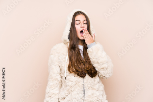 Young caucasian woman posing isolated yawning showing a tired gesture covering mouth with hand.