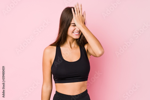 Young caucasian fitness woman doing sport isolated forgetting something, slapping forehead with palm and closing eyes.