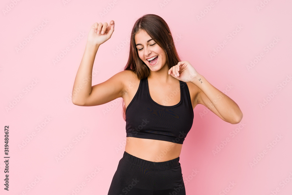 Young caucasian fitness woman doing sport isolated celebrating a special day, jumps and raise arms with energy.