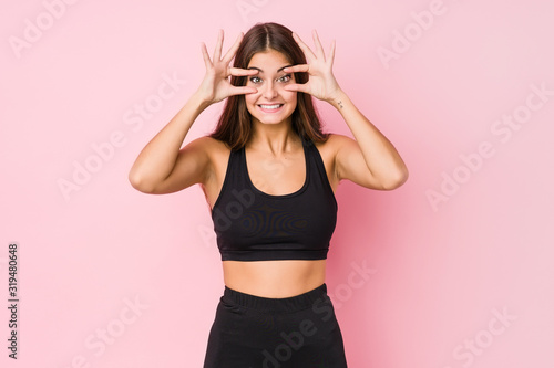 Young caucasian fitness woman doing sport isolated keeping eyes opened to find a success opportunity. © Asier