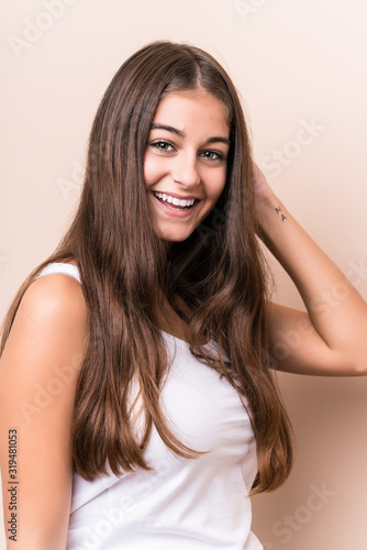 Foto Young cute caucasian woman against a beige background