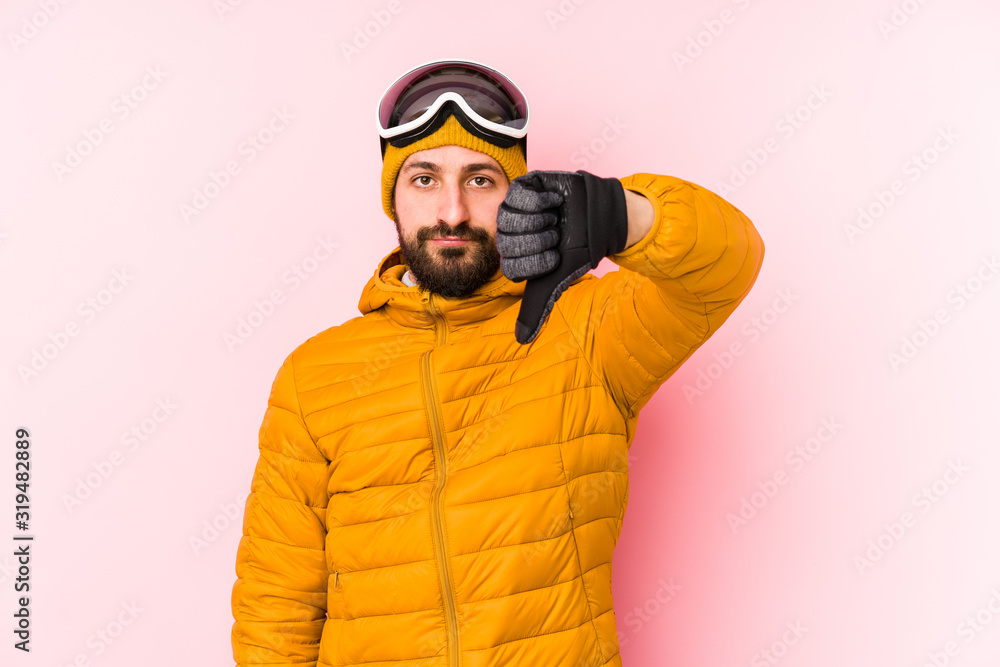 Young skier man isolated showing a dislike gesture, thumbs down. Disagreement concept.