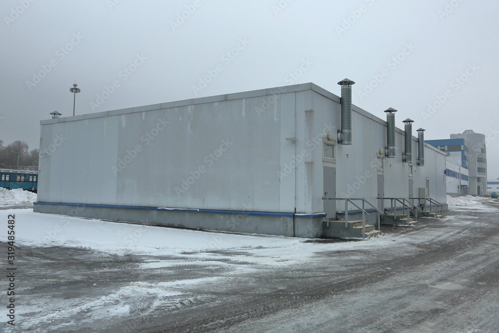 Gray industrial outbuilding of economic purpose on the factory site on a clouded day Gray industrial outbuilding of economic purpose on the factory site on a clouded day