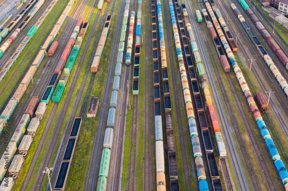 Aerial perspective view of railroad tracks, cargo sorting station. Many different railway cars with cargo and raw materials.
