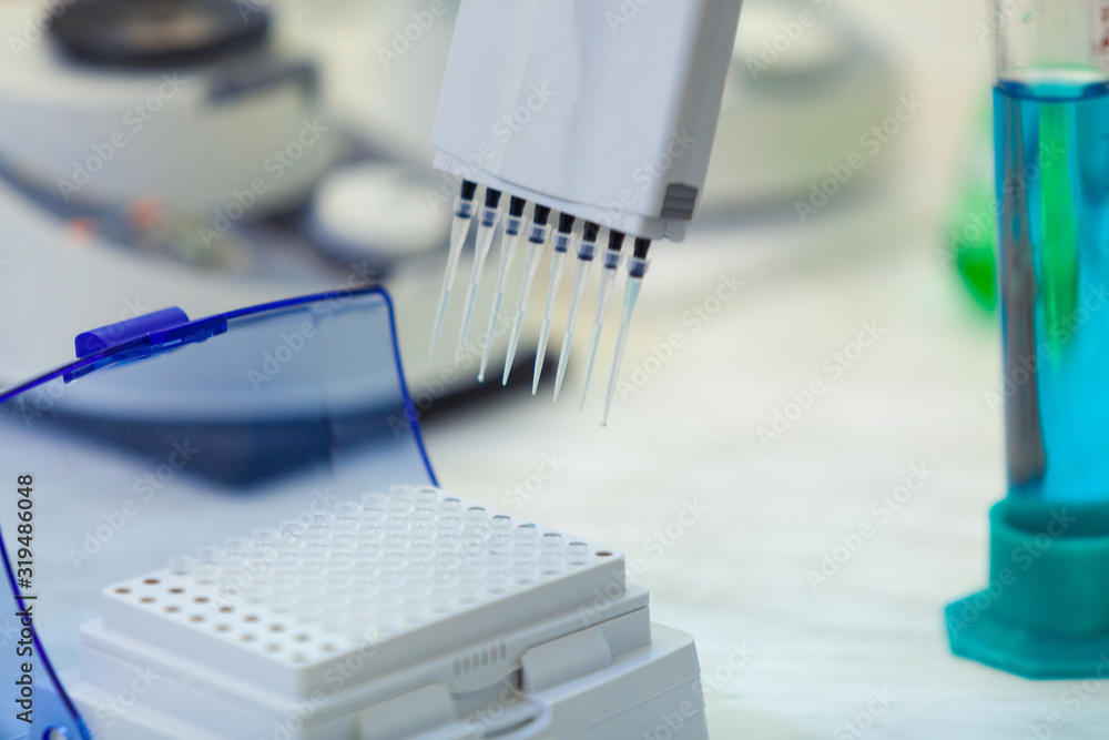 Laboratory worker puts samples into a tray making analysis for immunity viruses in a medical laboratory. Laboratory worker puts samples into a tray making analysis for immunity viruses in a medical laboratory.