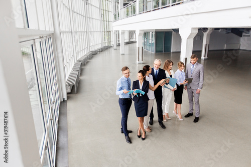 people, technology, work and corporate concept - business team with tablet pc computers and folders at office