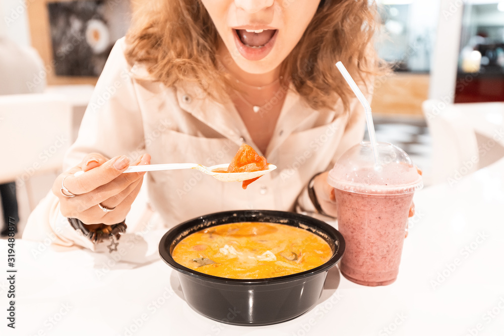 Girl eating Asian soup in foodcourt fast food cafe Girl eating Asian soup in foodcourt fast food cafe