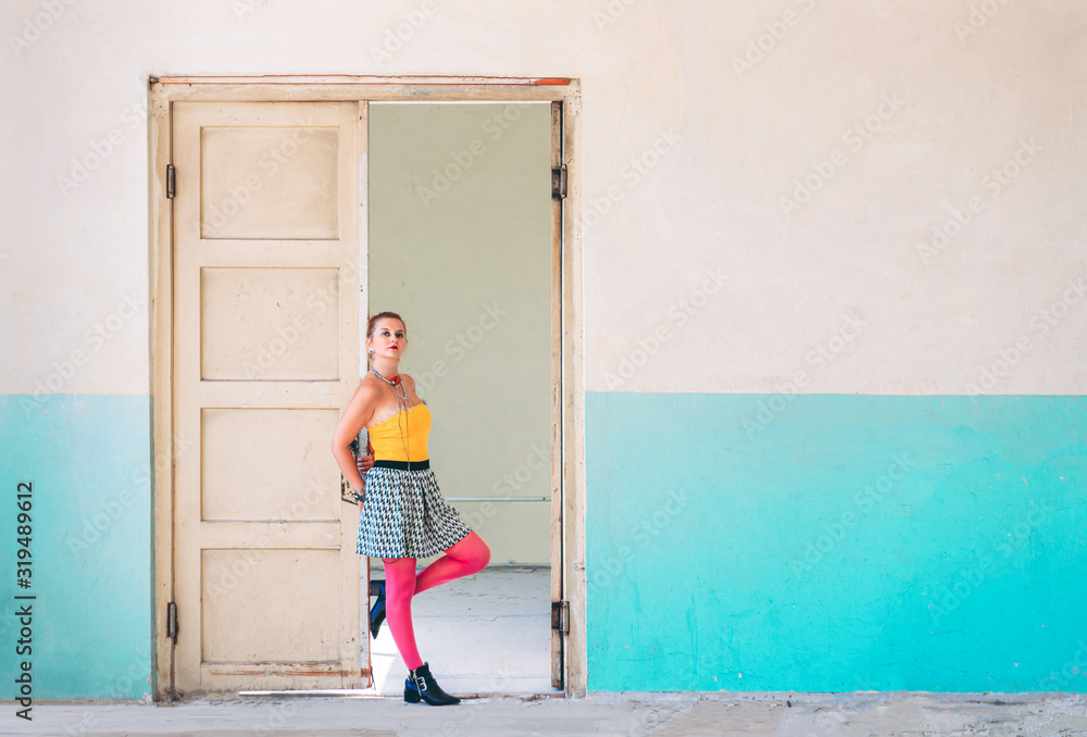 Cute girl in 80s outfit posing in an old building. 80s, retro fashion