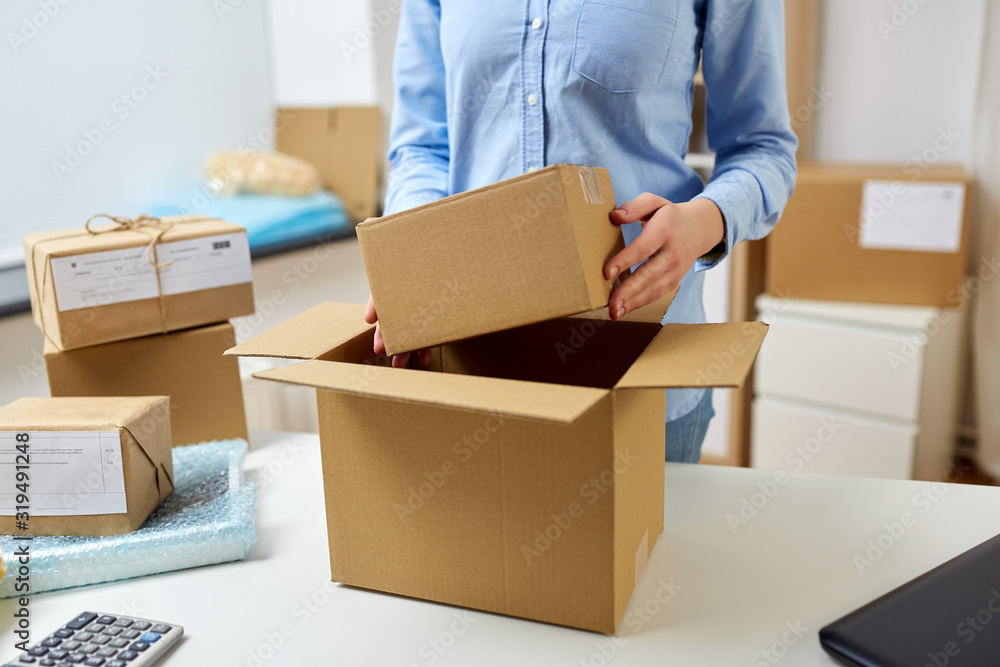 delivery, mail service, people and shipment concept - close up of woman packing parcel boxes at post office delivery, mail service, people and shipment concept - close up of woman packing parcel boxes at post office