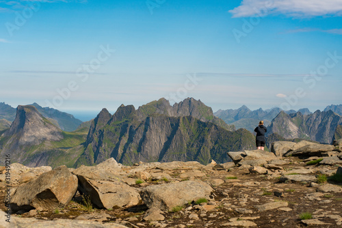 Beautiful Norwegian Landscapes of Mountain Munken on the Munken Trail - Happy Female Hiker enjoying view of Lofoten Island from top of Peak in Northern Norway during vacation abroad. photo