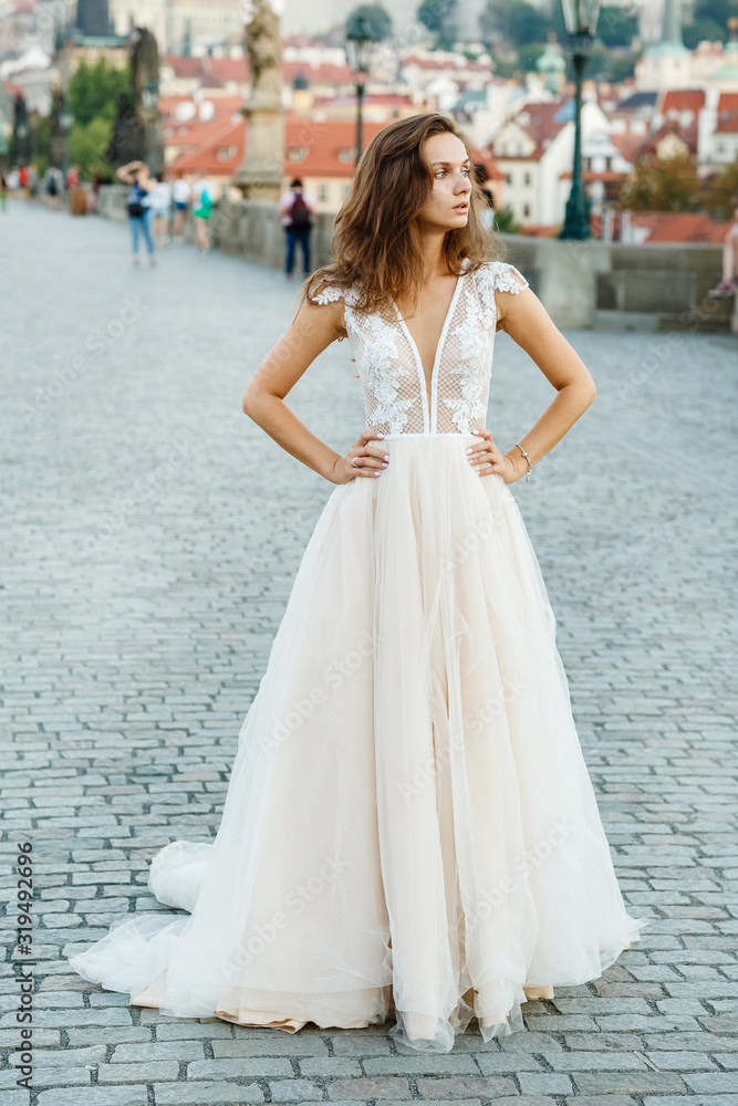 Young bride in a beautiful dress walks on the bridge