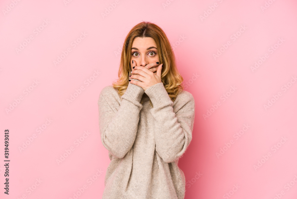 Young blonde cute woman wearing a sweater isolated shocked covering mouth with hands. Young blonde cute woman wearing a sweater isolated shocked covering mouth with hands.