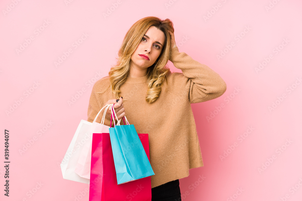 Young blonde woman holding shopping bags isolated being shocked, she has remembered important meeting. Young blonde woman holding shopping bags isolated being shocked, she has remembered important meeting.