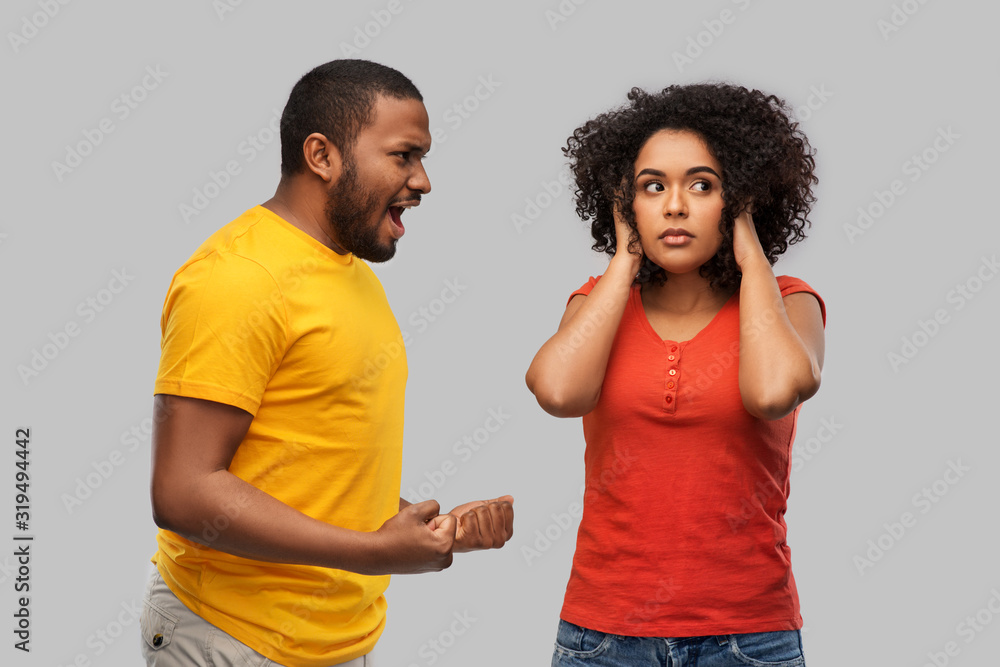 Fototapeta premium relationships and people concept - unhappy african american couple having argument over grey background