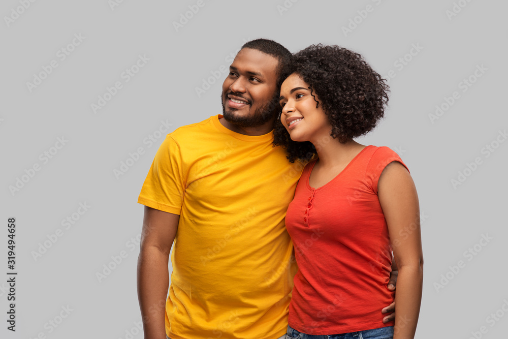 relationships and people concept - happy african american couple hugging over grey background relationships and people concept - happy african american couple hugging over grey background