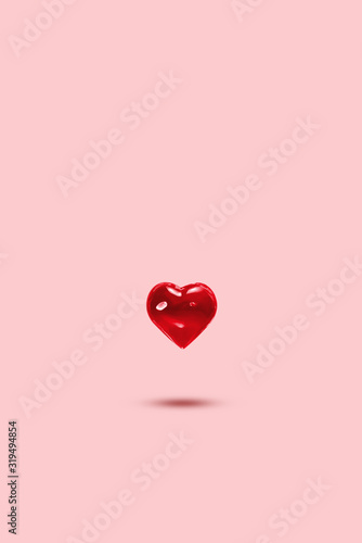 Glass heart on a pastel background, levitation. Symbol of love, minimalism. Concept of love, Valentine's Day photo