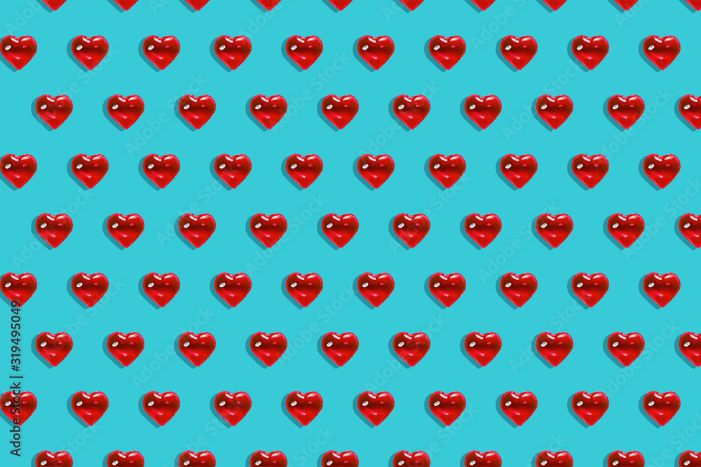 Valentine's day background. Pattern of glass red hearts on a blue background. Card minimalism, Symbol of love Valentine's day background. Pattern of glass red hearts on a blue background. Card minimalism, Symbol of love