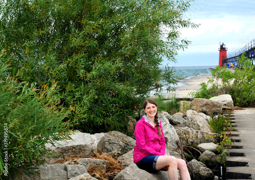 Happy Tourist Sits on Rocks by South Haven Light photo