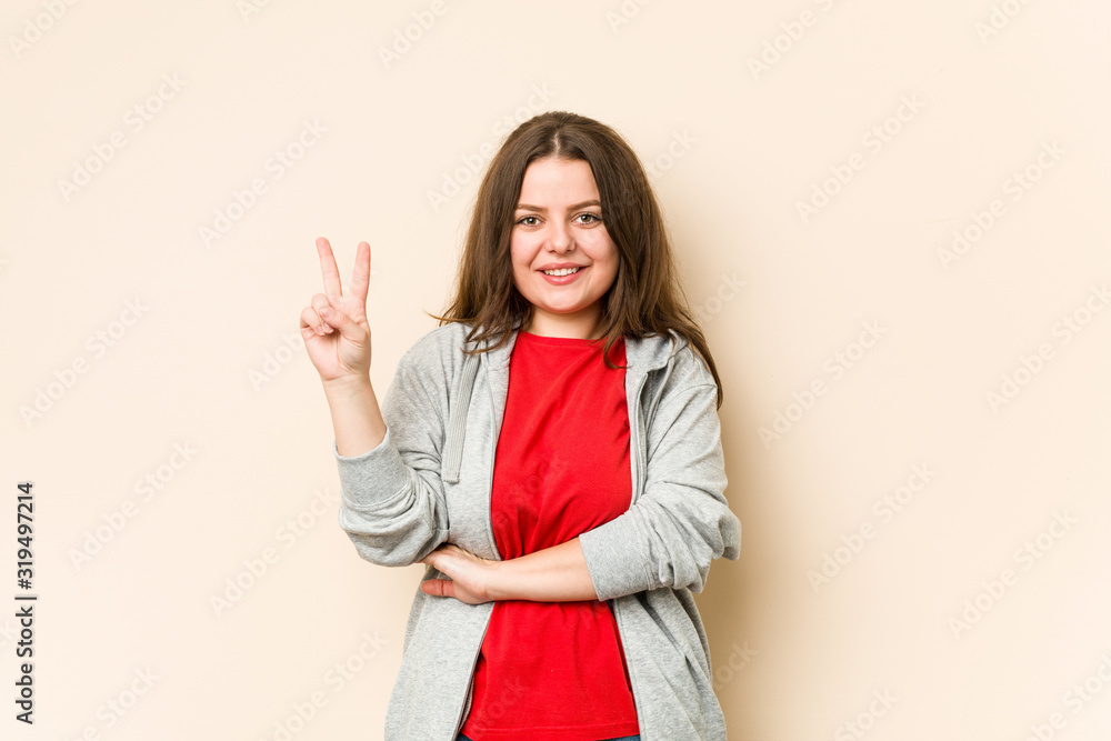 Young sporty curvy woman showing number two with fingers. Young sporty curvy woman showing number two with fingers.