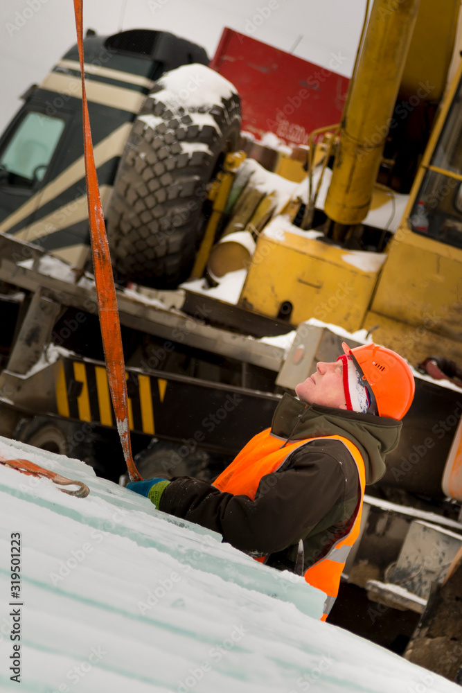 Slinger in orange helmet on shipment of ice blocks Slinger in orange helmet on shipment of ice blocks