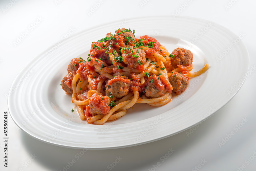 Plate of spaghetti with tomato and meatballs with chopped parsley Plate of spaghetti with tomato and meatballs with chopped parsley